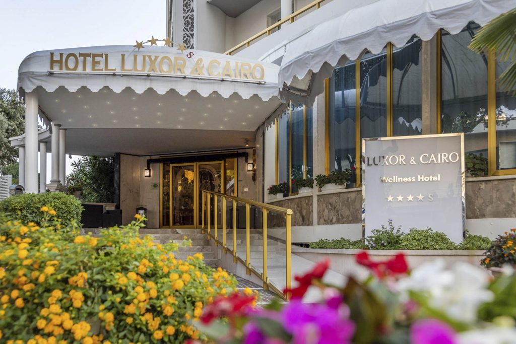 Der Eingang des Hotels Luxor & Cairo, umgeben von blühenden Pflanzen und einem eleganten Design.