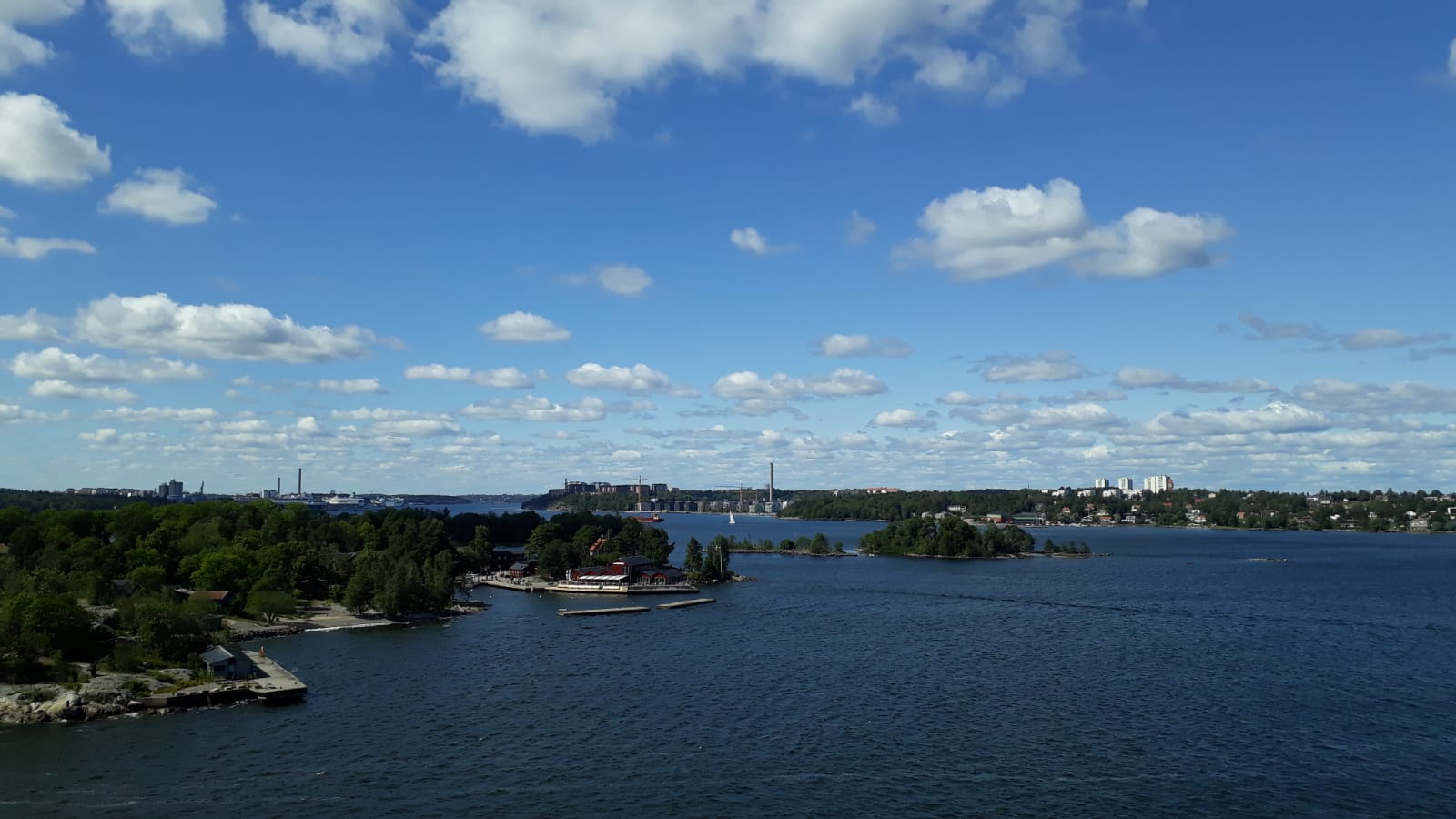 Eine schöne Landschaft mit Wasser, Inseln, Bäumen und einem blauen Himmel voller Wolken. Ideal für Erholung.