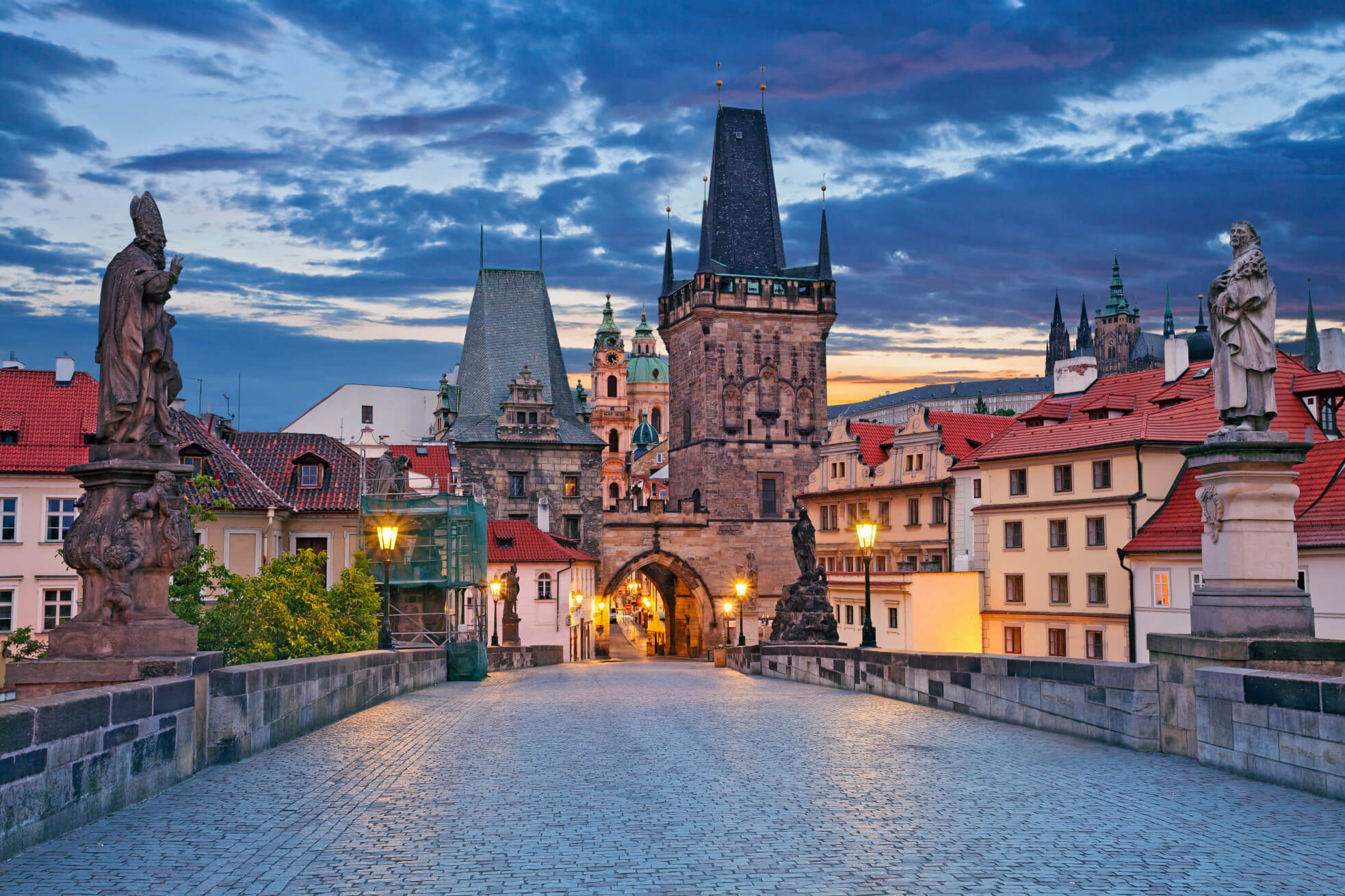 Die Karlsbrücke in Prag, umgeben von historischen Gebäuden und Statuen, bei wunderschönem Abendlicht.