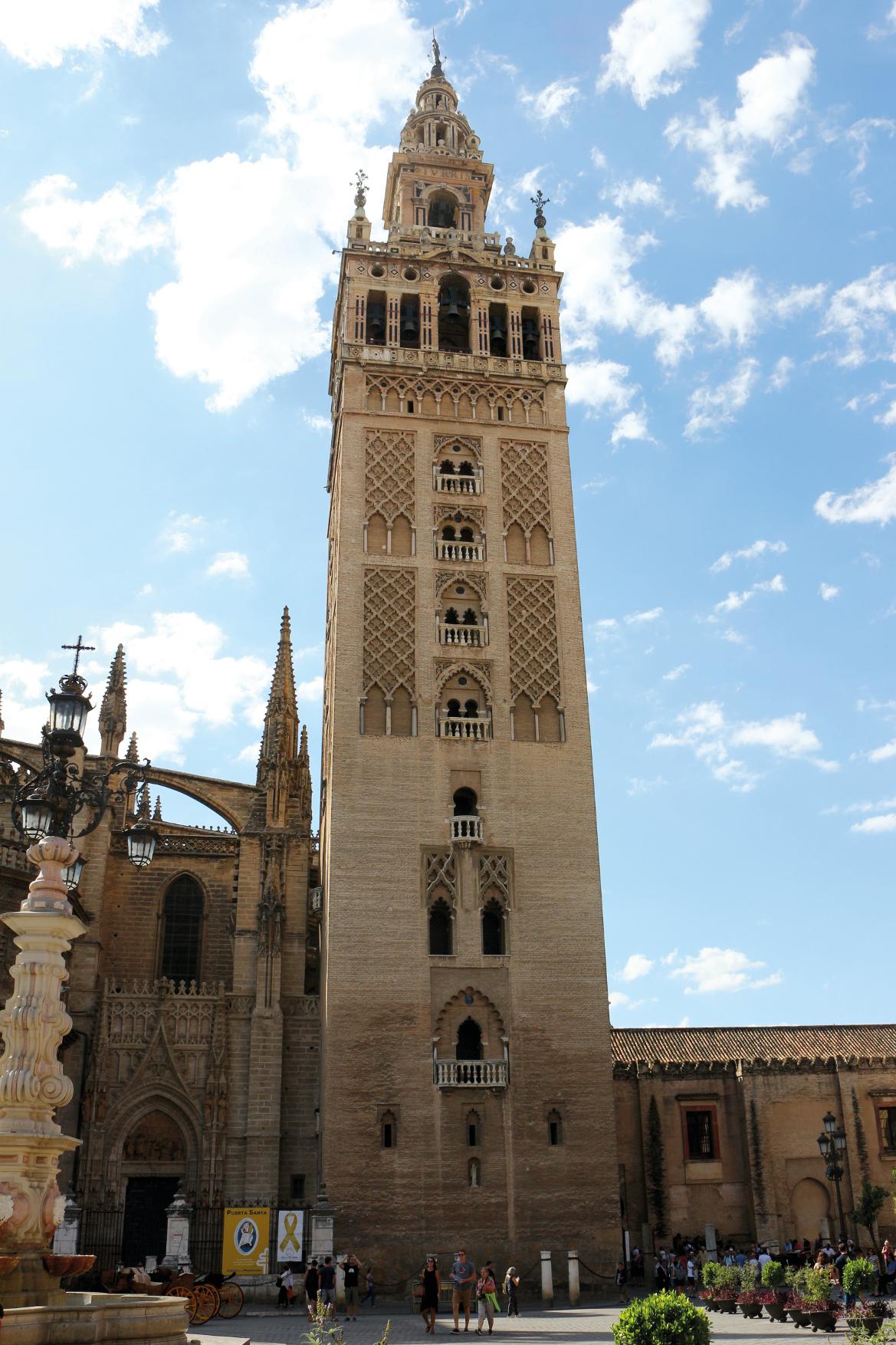 Die beeindruckende Glockenturm der Kathedrale von Sevilla erhebt sich majestätisch unter blauem Himmel.