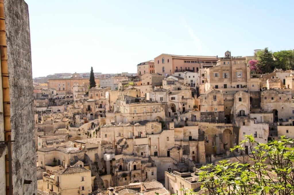 Eine malerische Stadtansicht mit vielen alten, zusammengebauten Häusern und einem blauen Himmel.