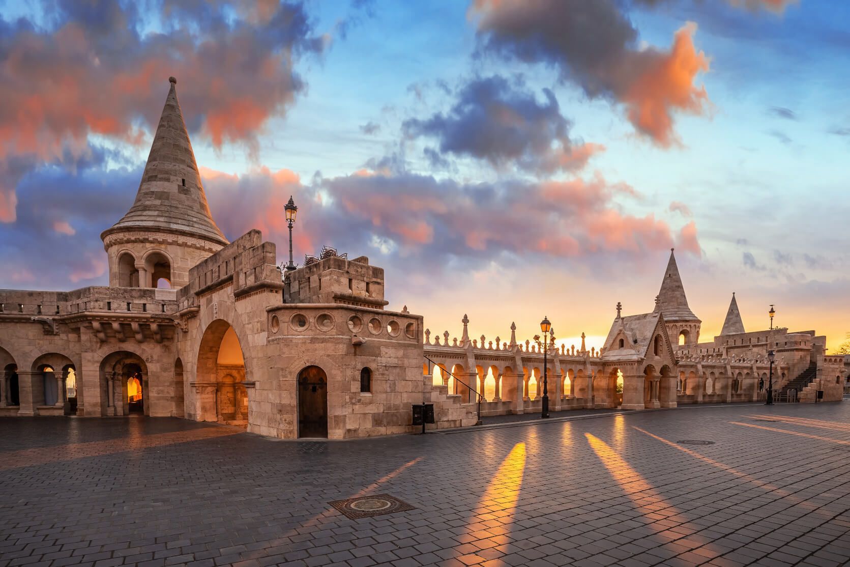 Eine beeindruckende Architektur mit Türmen, Bögen und schönen Wolken am Himmel während des Sonnenuntergangs.