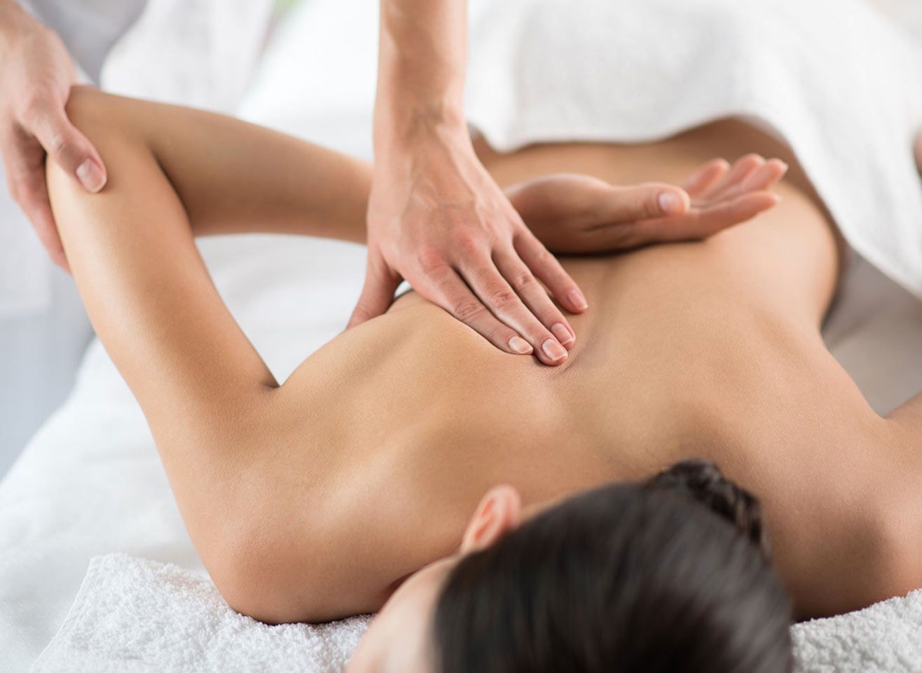 Eine Person erhält eine Rückenmassage, während sie entspannt auf einer Liege liegt. Entspannung und Wohlbefinden.