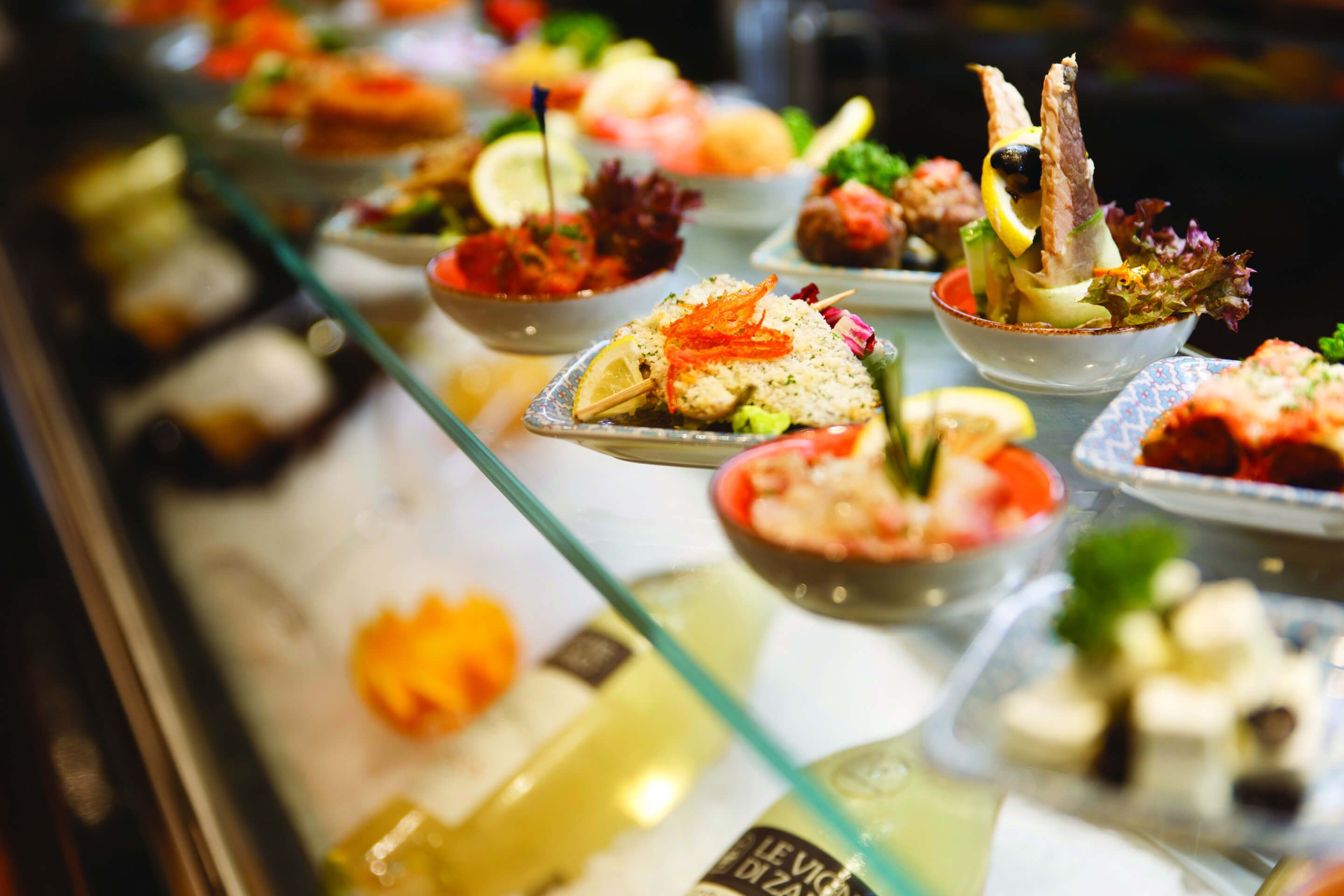 Ein Buffet mit verschiedenen appetitlichen Gerichten und dekorativen Beilagen in ansprechender Präsentation.