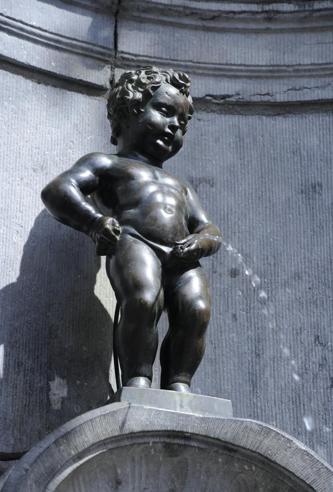 Eine Bronzefigur eines kleinen Jungen, der im Brunnen Wasser spritzt. Bekannt als Manneken Pis in Brüssel.