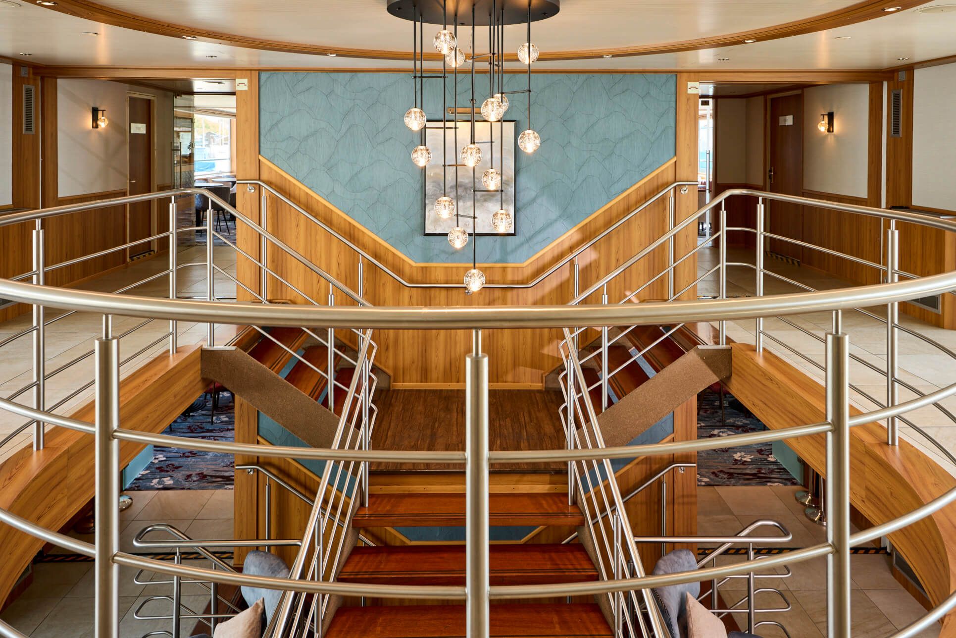 Eine elegante Treppe mit Holz- und Metallakzenten, umgeben von stilvoller Innenarchitektur und Beleuchtung.