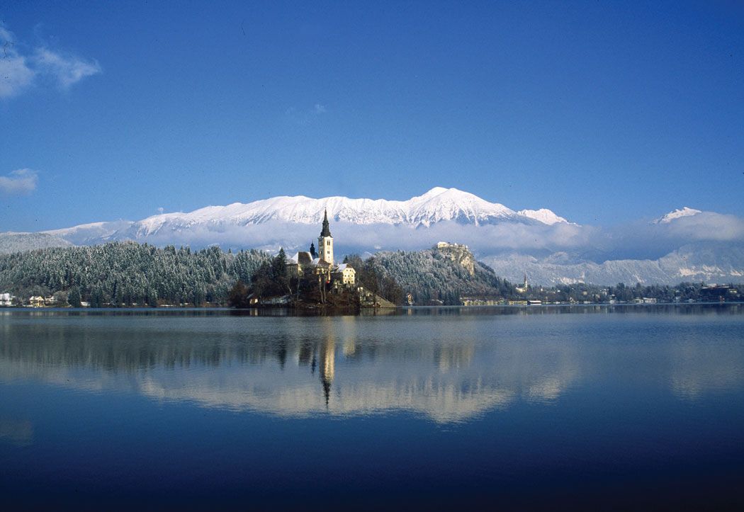 Der malerische Blick auf den schneebedeckten Bergsee mit einer idyllischen Insel und klar blauem Himmel.