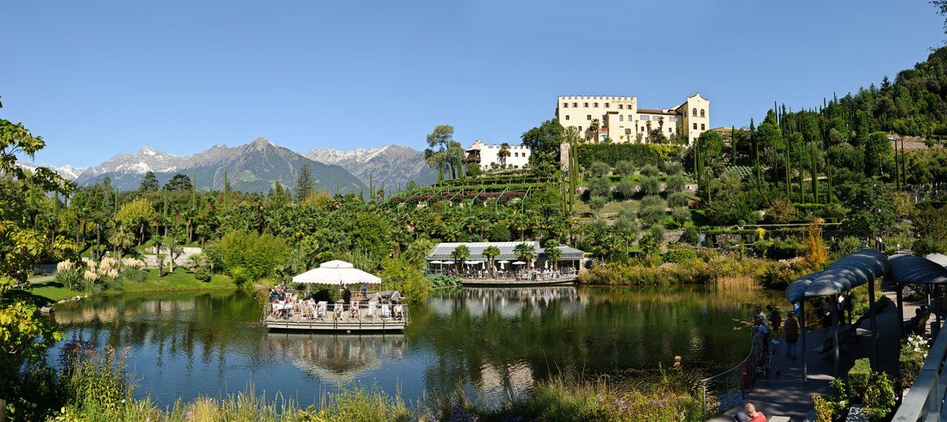 Ein schöner Park mit einem Teich, umgeben von Bergen und üppiger Vegetation, ideal für Entspannung und Genuss.