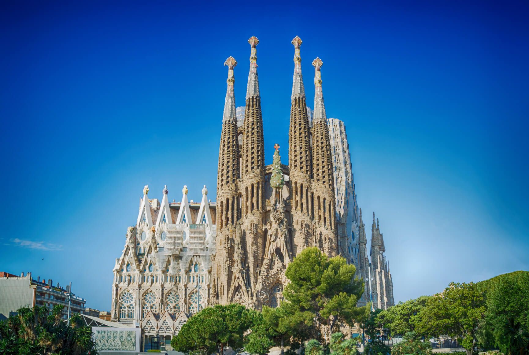 Die Sagrada Família in Barcelona beeindruckt mit einzigartiger Architektur und hohen Türmen gegen blauen Himmel.