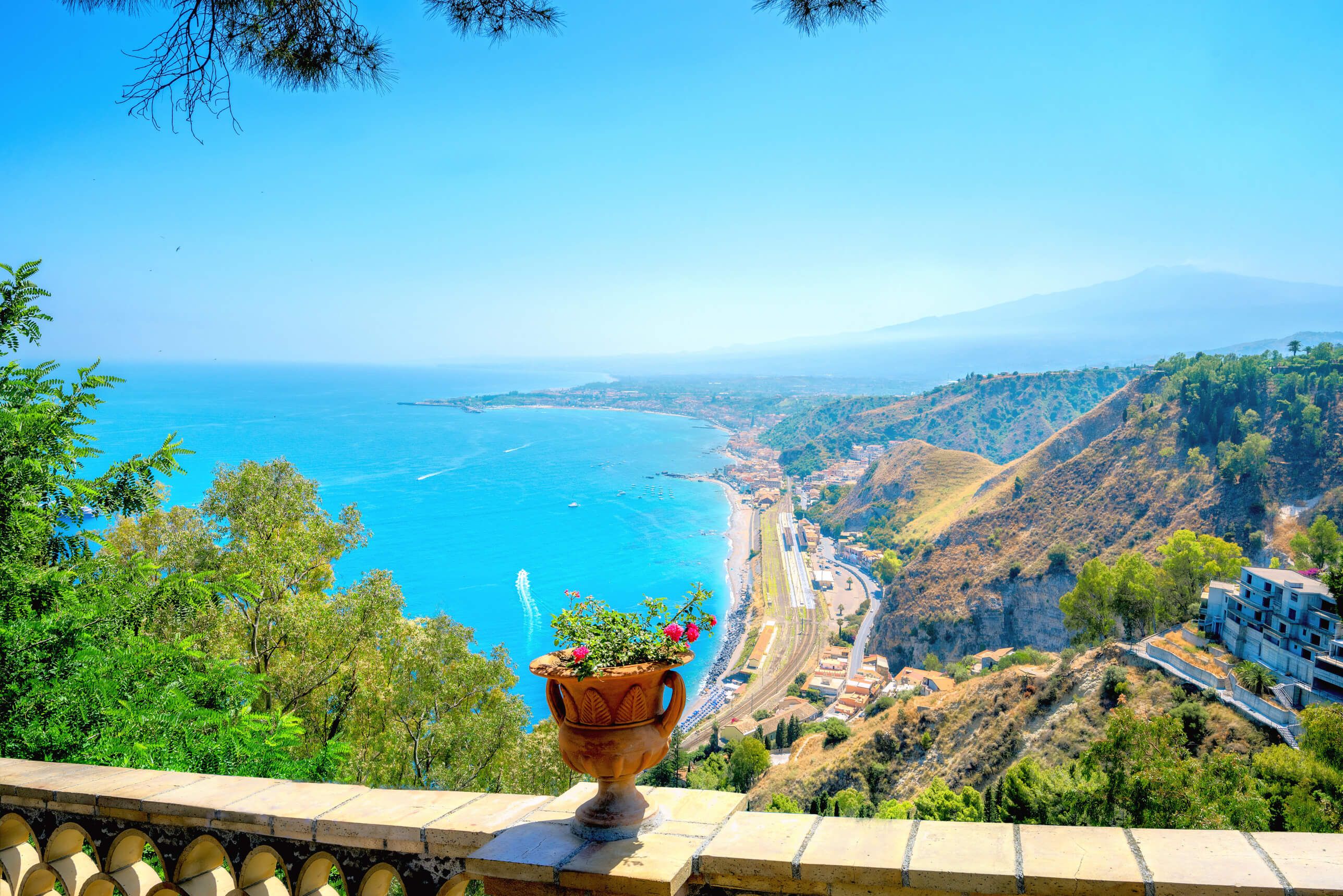 Blick auf das blaue Meer, die Küste und die Berge, dekoriert mit Blumentopf am Geländer. Traumhafte Landschaft!