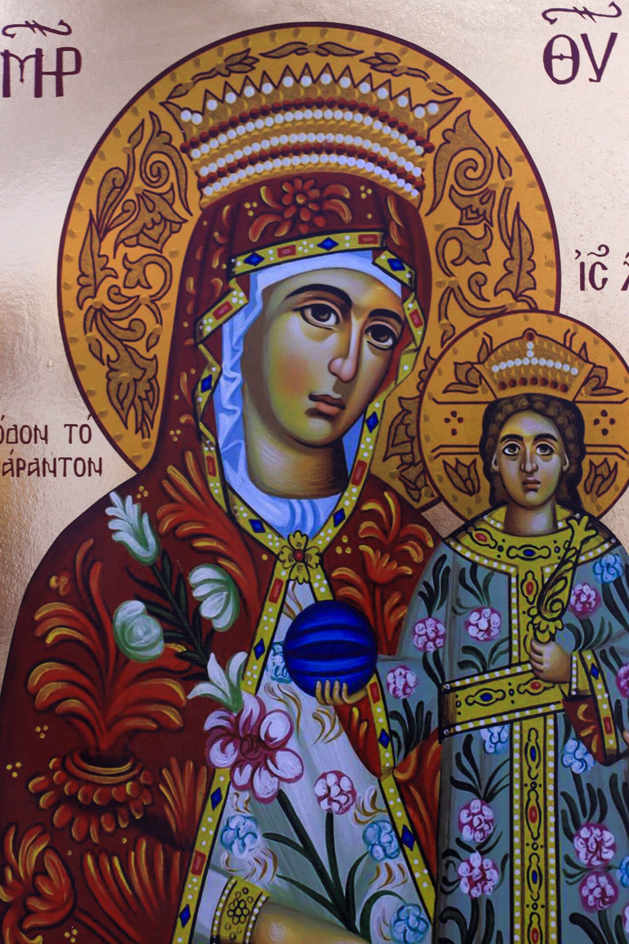 Ein religiöses Gemälde zeigt die Jungfrau Maria mit dem Kind Jesus, reich verziert und farbenfroh.