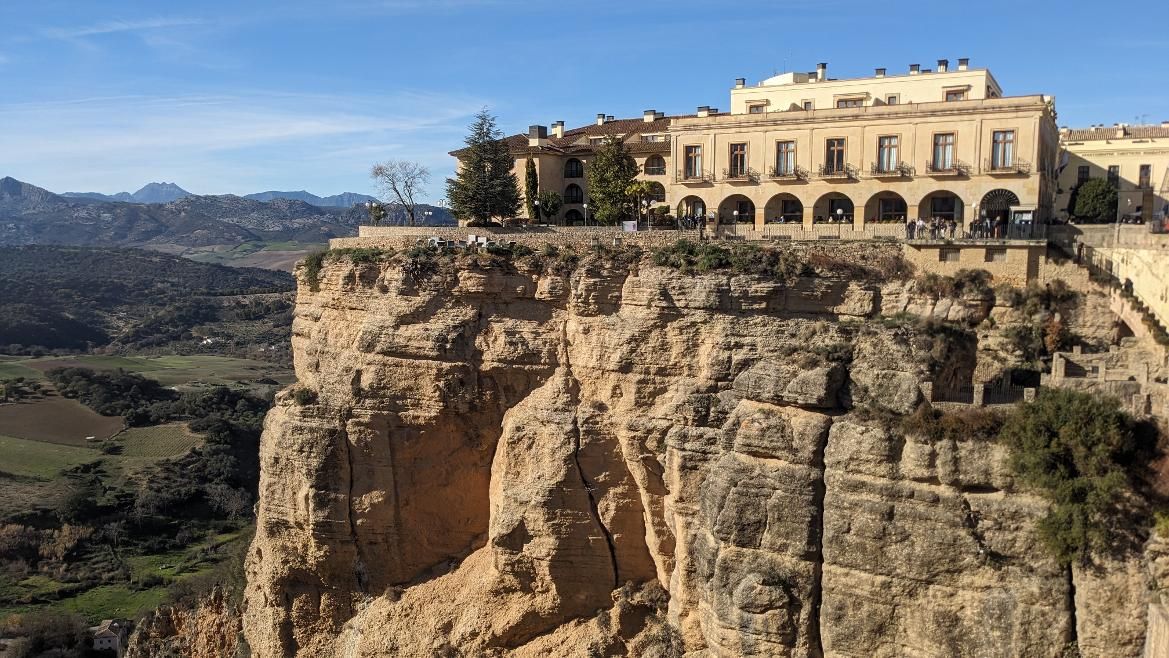 Eine beeindruckende Klippe mit einem charmanten Gebäude und einer schönen Landschaft im Hintergrund.