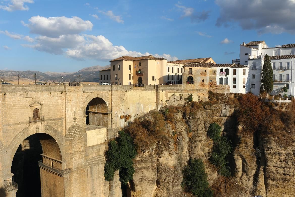 Die beeindruckende Brücke überspannt eine Schlucht, umgeben von malerischen Häusern und schönem Himmel.