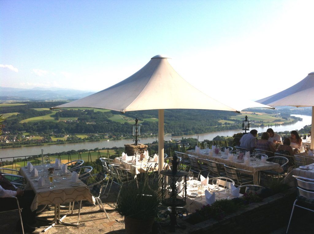 Wunderschöne Terrasse mit Blick auf den Fluss, umgeben von Natur, ideal für ein entspanntes Essen im Freien.