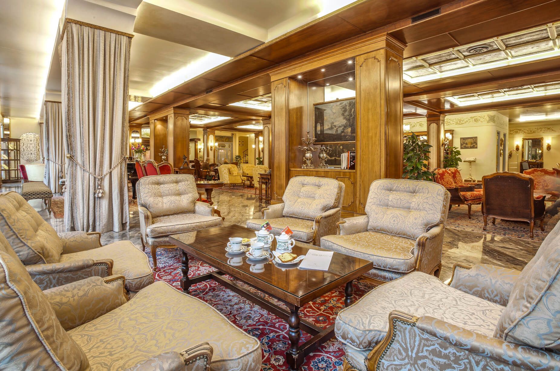 Elegante Lounge mit bequemen Sofas, einem Holztisch und Tee auf einem schönen Teppich. Gemütliche Atmosphäre.