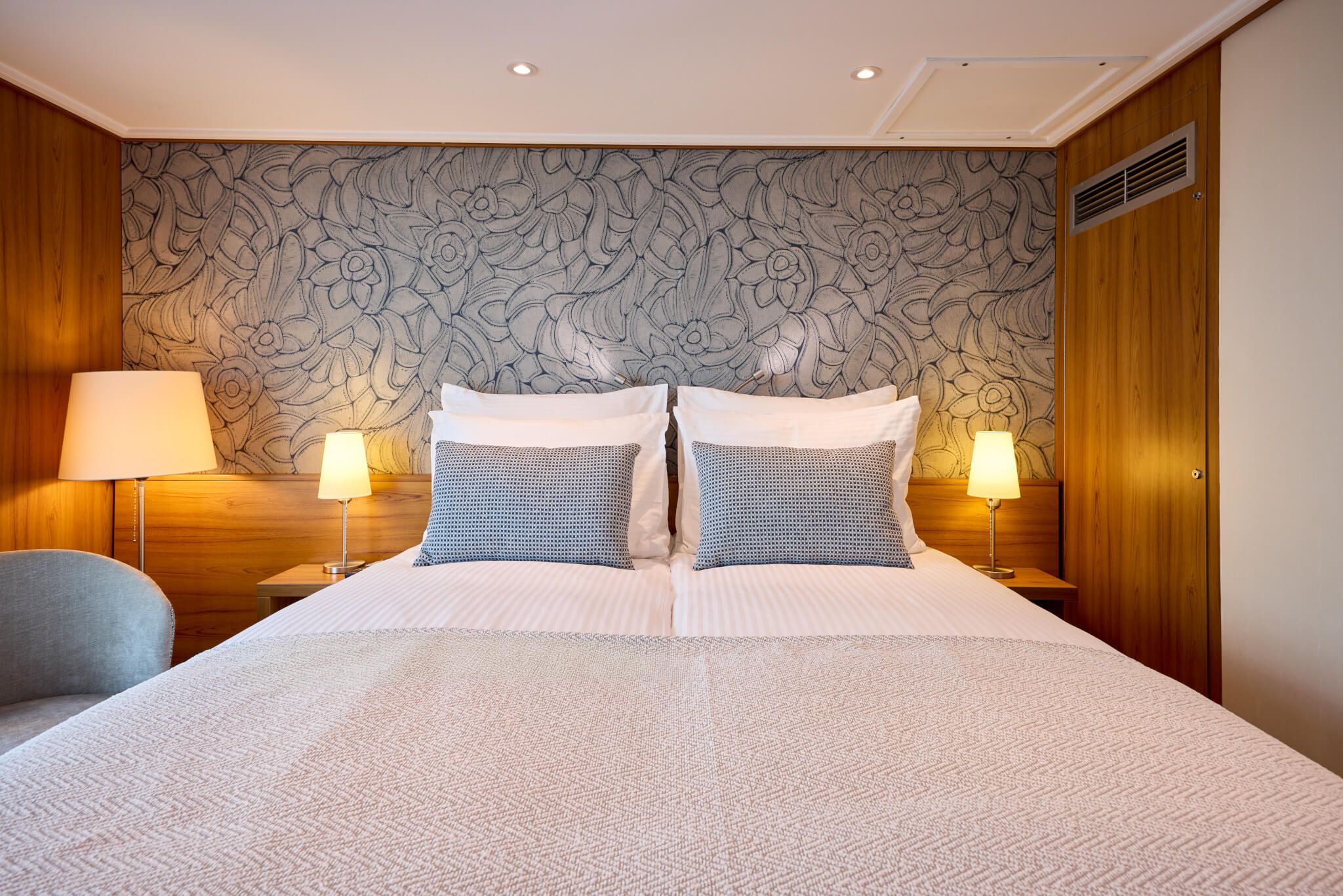 Elegantes Schlafzimmer mit Holzvertäfelung, schönen Lampen und floralem Wanddesign, gemütlich und einladend.