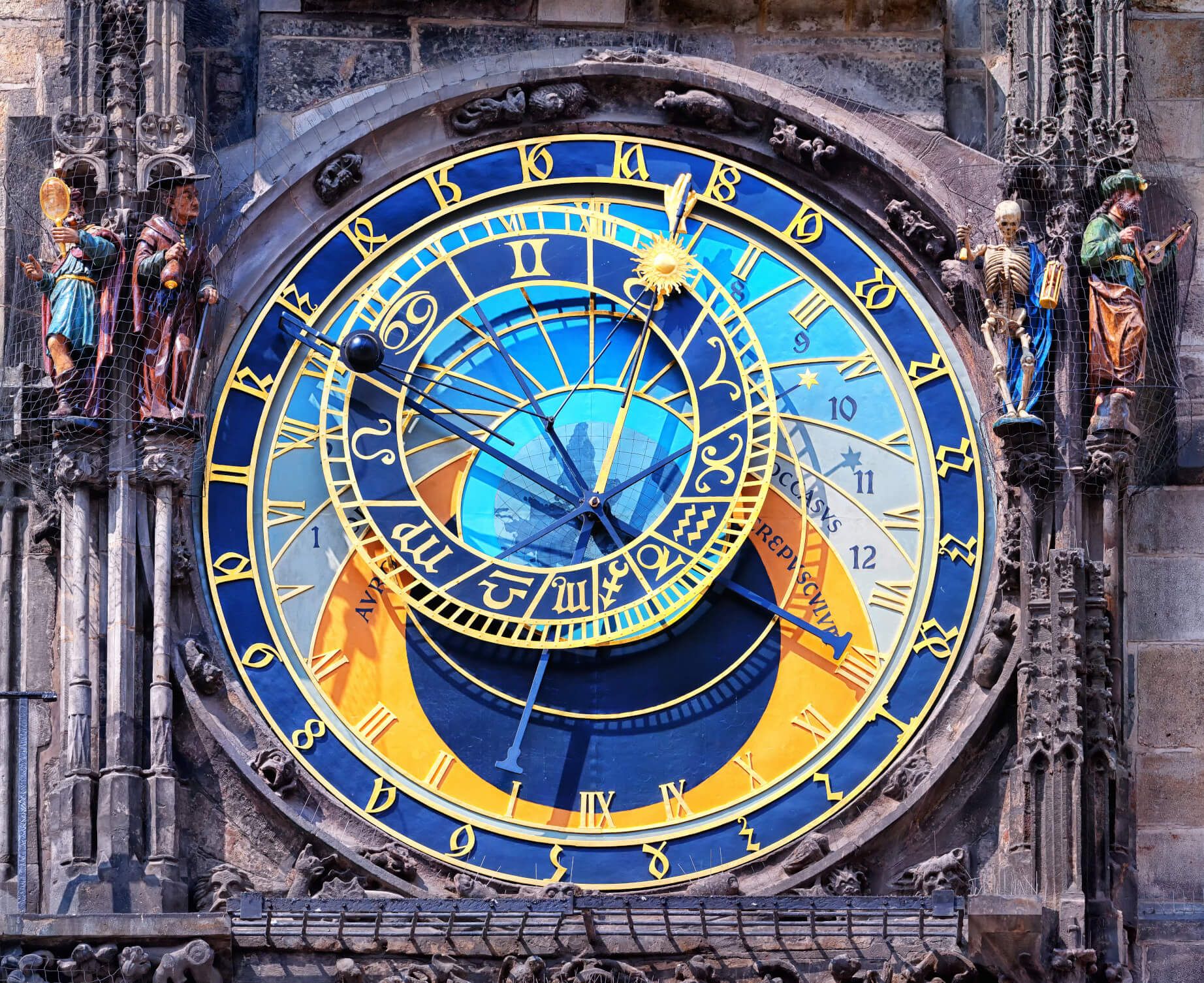 Das Bild zeigt eine farbenfrohe astronomische Uhr mit Skulpturen und römischen Ziffern in Prag.