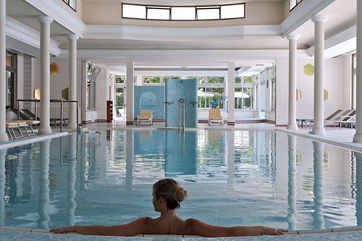 Ein eleganter Wellnessbereich mit einem Schwimmbecken und entspannenden Liegen, ideal für Erholung und Ruhe.