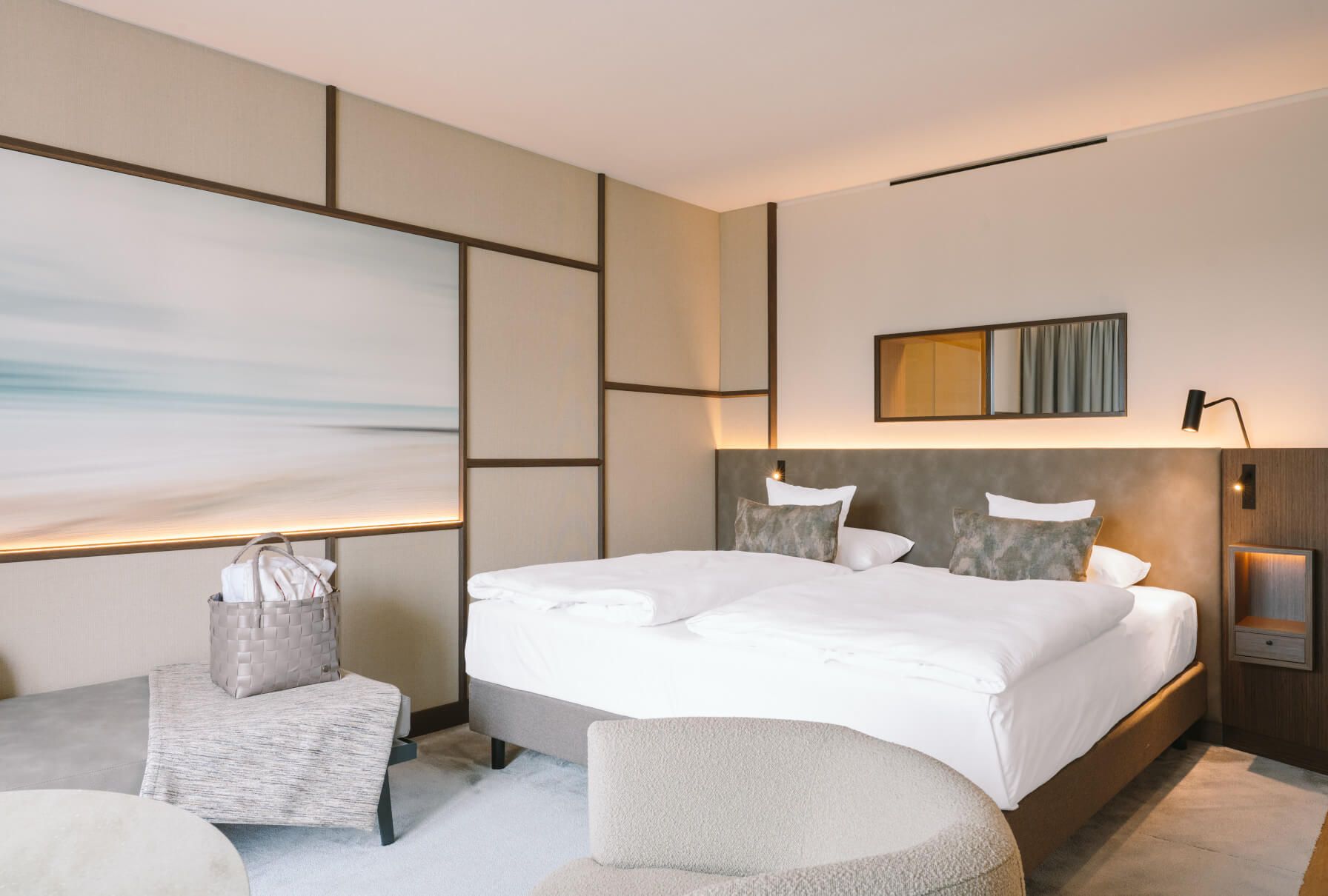 Elegantes Hotelzimmer mit zwei Betten, neutralen Tönen und modernem Design, ideal für entspannende Aufenthalte.