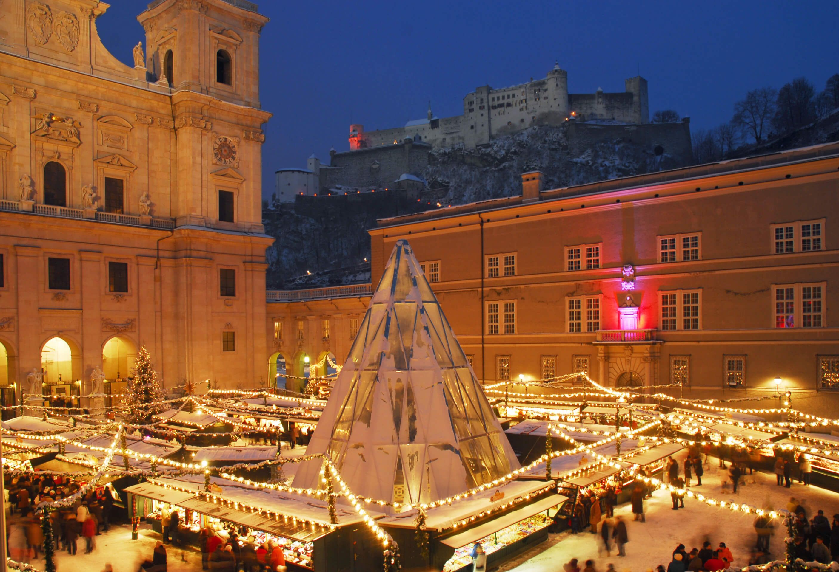 Ein festlich beleuchteter Weihnachtsmarkt mit schönen Ständen und einer festlichen Atmosphäre in der Abenddämmerung.