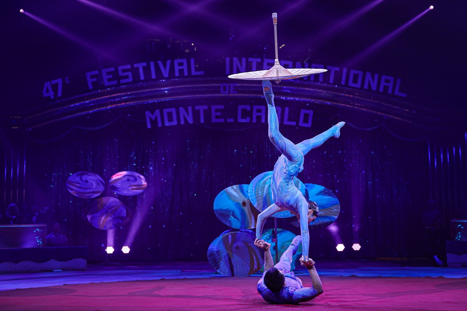 Akrobaten führen eine beeindruckende Darbietung im Monte Carlo Zirkusfestival auf, umgeben von bunten Lichtern.